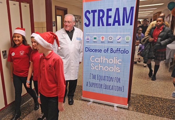 Bishop Richard Malone, wearing a lab coat presented to him by students, walks with students from Catholic Academy of Niagara Falls during the Diocese of Buffalo 3rd Annual X-Stream Games and Expo. Area Catholic elementary and middle school students compet